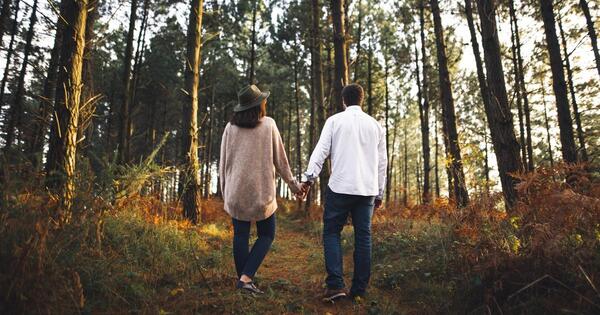 Two people walking together on a tree-lined path in relaxed posture